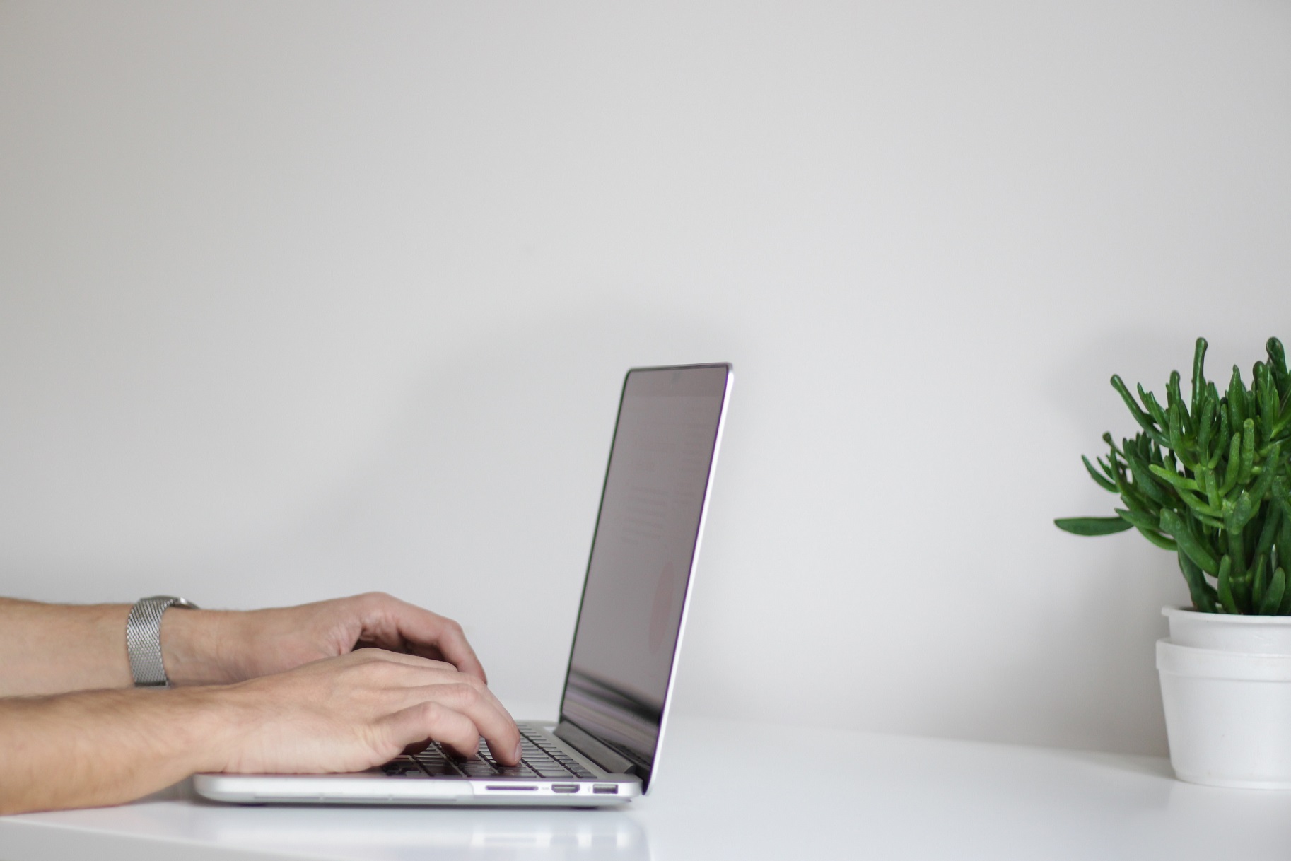 A picture of someone's hands on a laptop keyboard