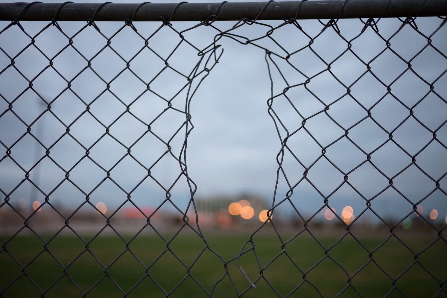 An image showing a large hole in a perimeter fence